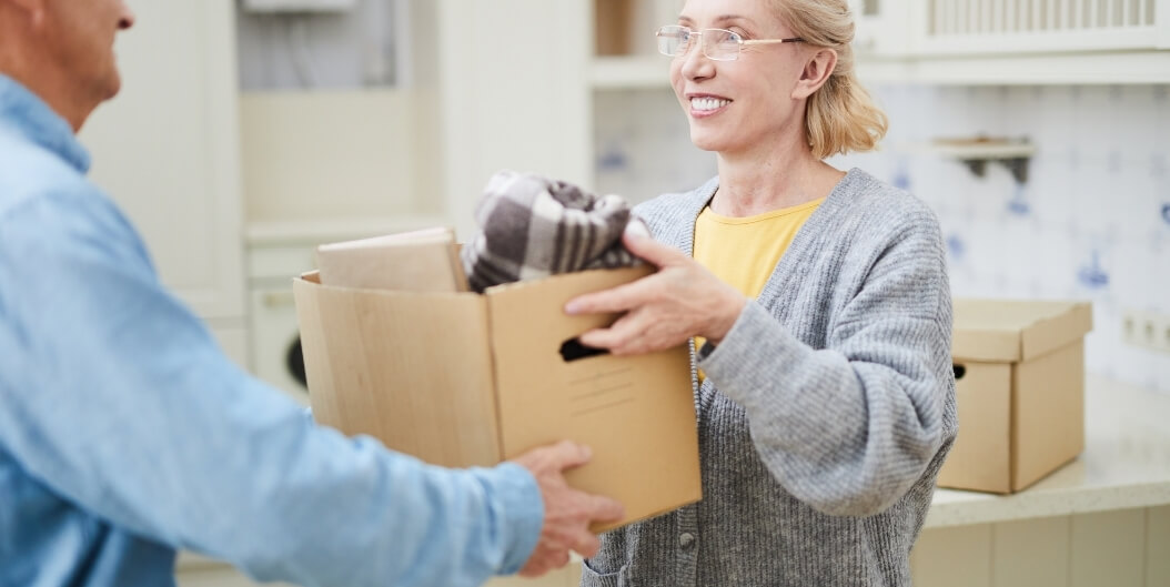 Senior Woman Unpacking Moving Boxes in Apartment at Independent Living Facility