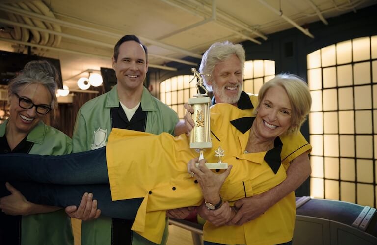 Elderly Friends Celebrating a Bowling Trophy Win Together in Independent Living
