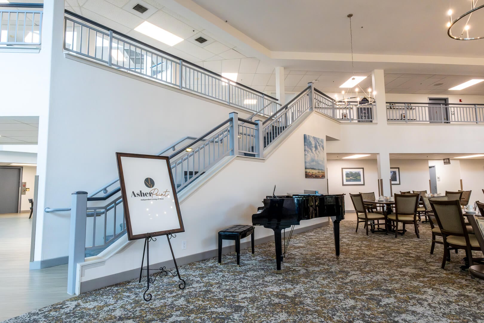 Bright Lobby With Grand Piano and Staircase at an Independent Living Community