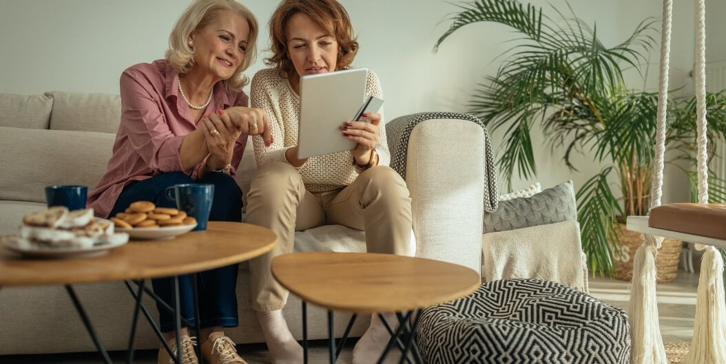 Elderly Women Browsing Tablet Together in Independent Living Facility